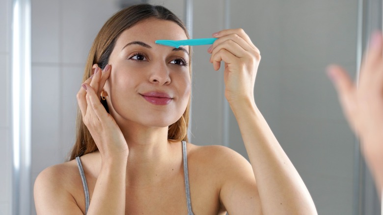 Woman using dermaplane razor