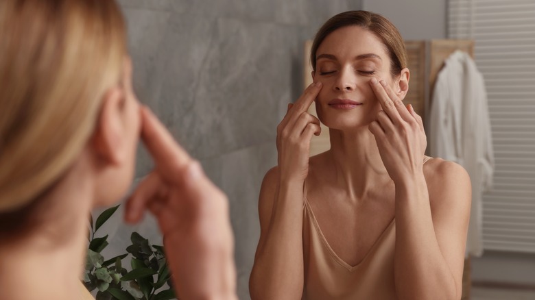 Middle-aged woman tapping cheeks massage