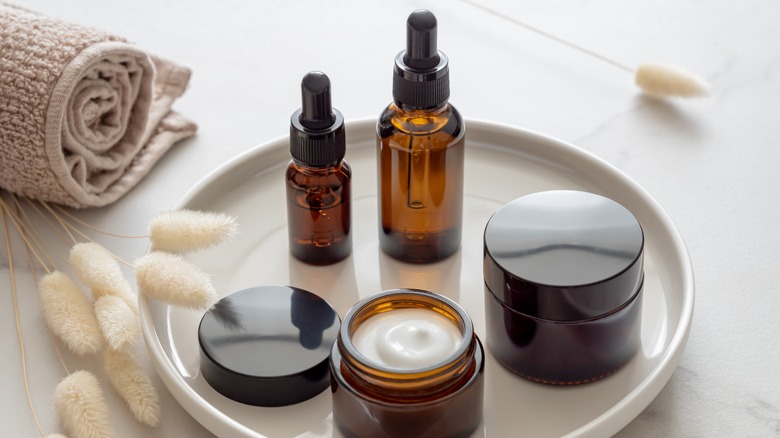 skin creams and serum bottles on a white tray