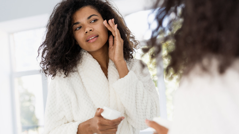 woman applying anti-aging serum to her face 