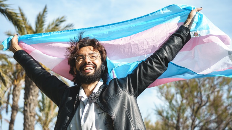 Trans man holding trans flag