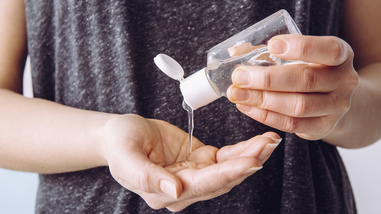 Person putting on hand sanitizer