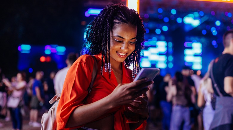 woman texting at music festival