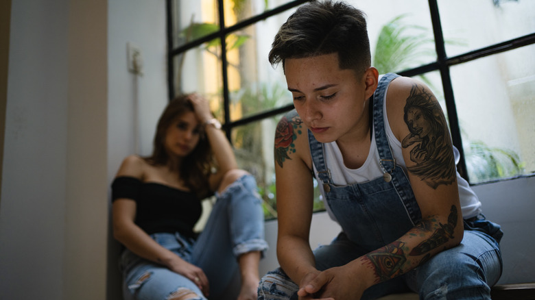 Sad couple sitting in window