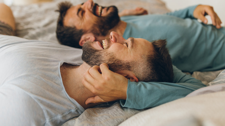 two men laughing bed