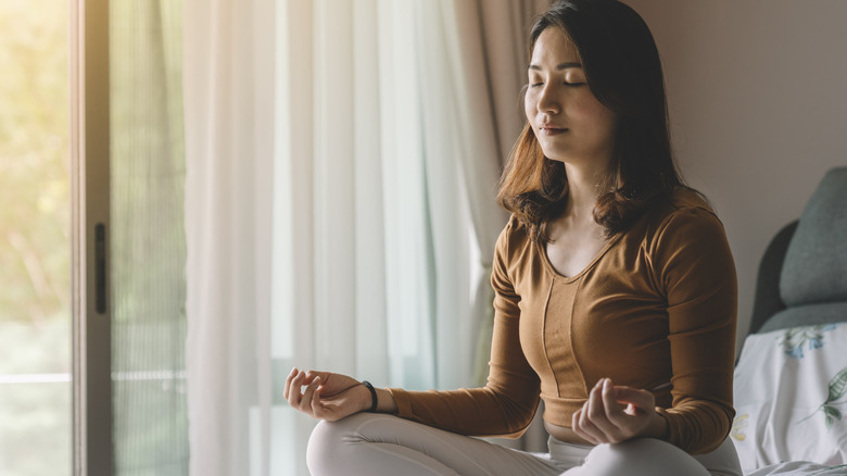 Woman meditating on bed