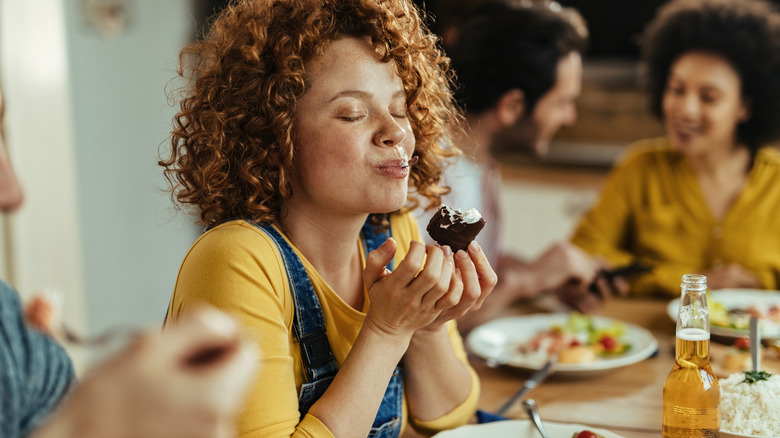 woman closing eyes while eating