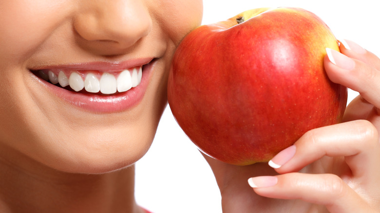 smiling woman holding apple