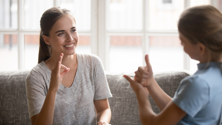 women smiling using sign language