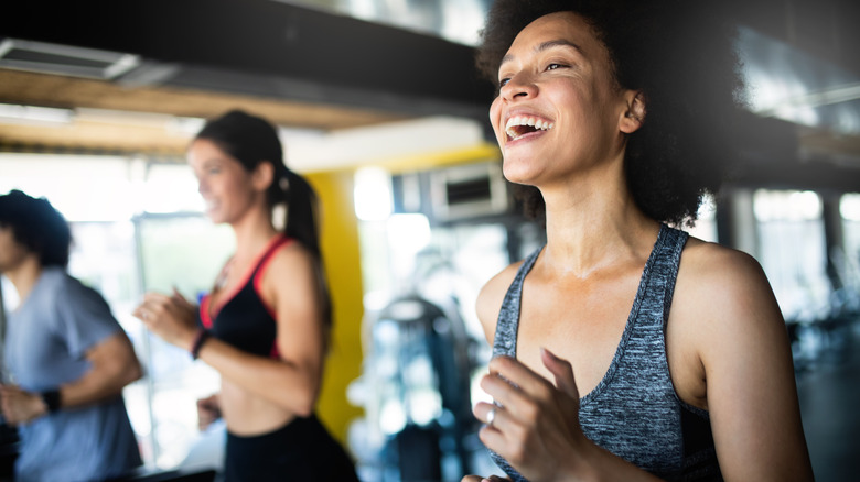 Woman smiling on treadmill, other people in background