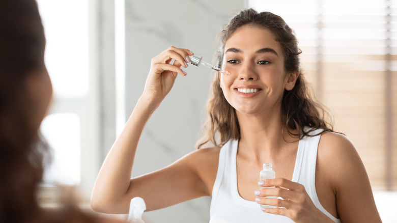 woman putting oil on her face