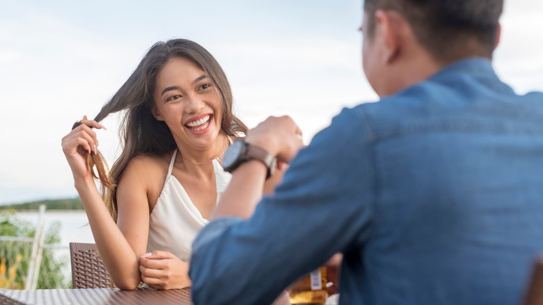 girl twirling hair on date