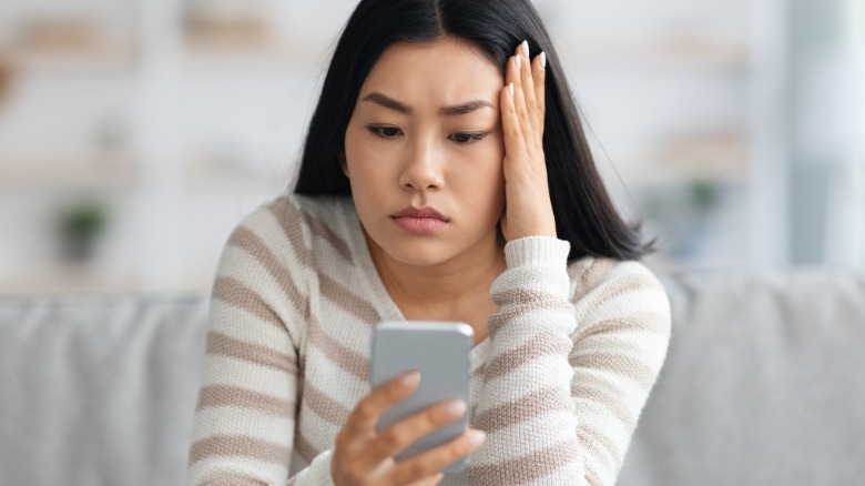 Woman looking stressed at phone