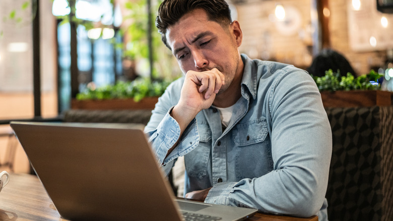 Man frowning at laptop