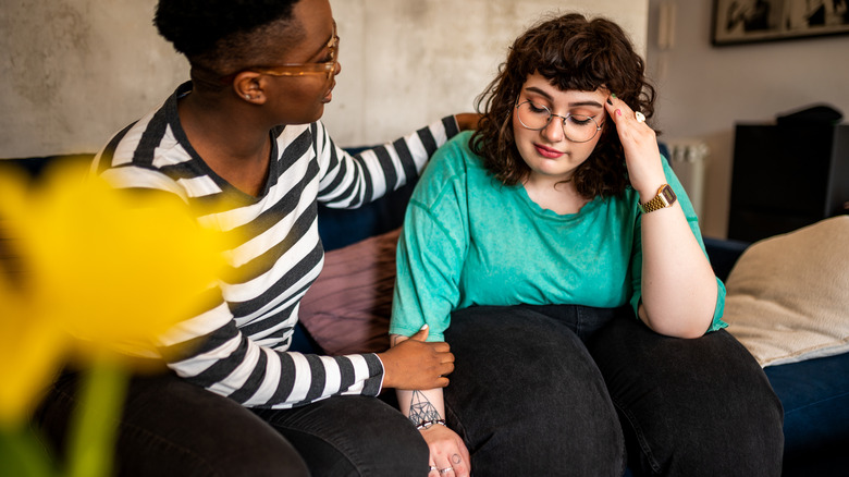 Young woman comforting friend