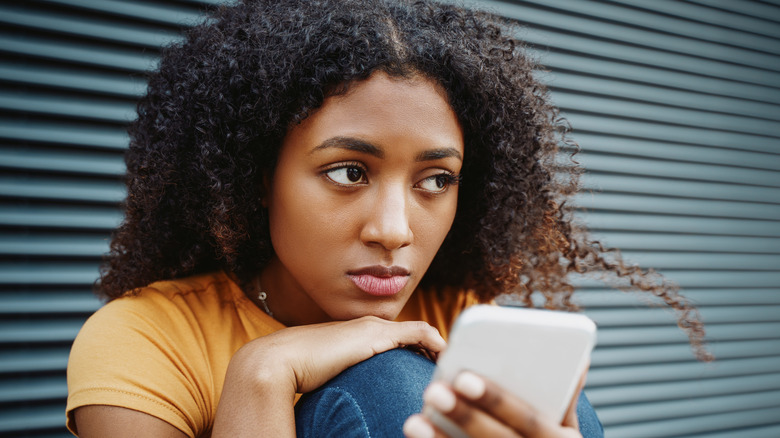 Upset woman using phone