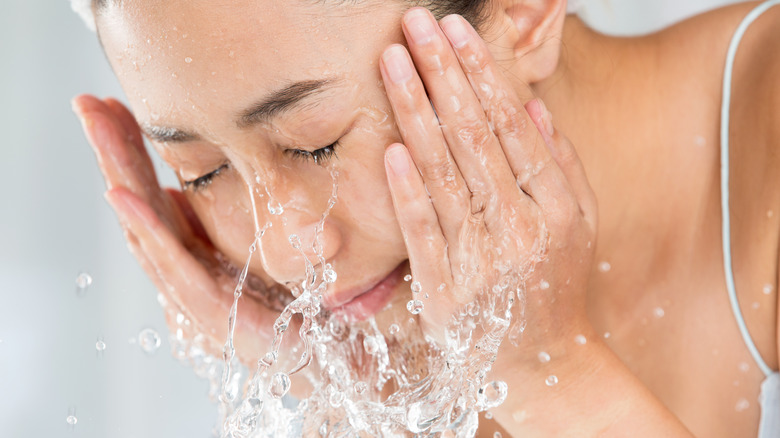 Woman rinsing face with fingers 