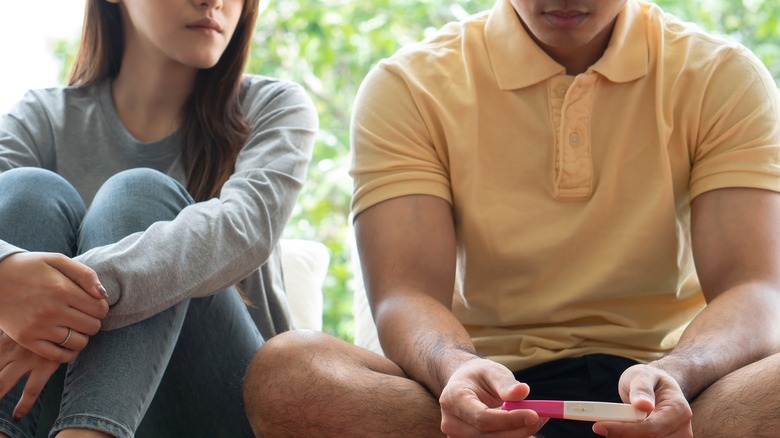 Asian couple looking at negative pregnancy test 