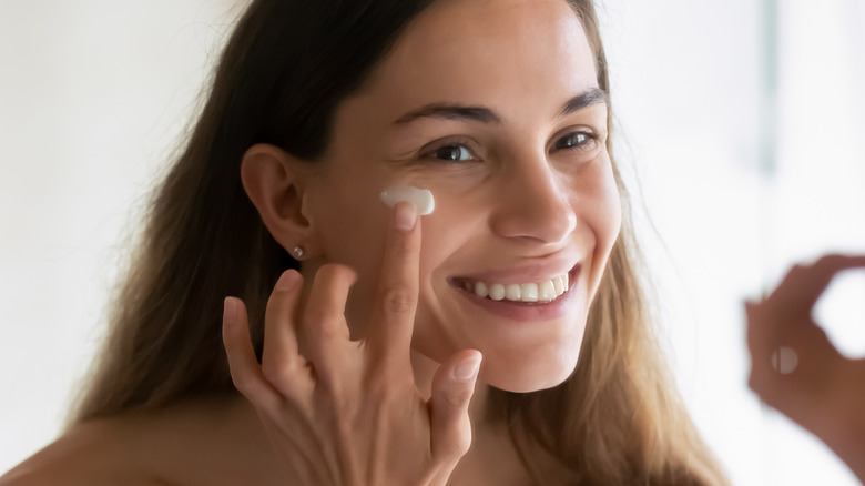 female applying face cream