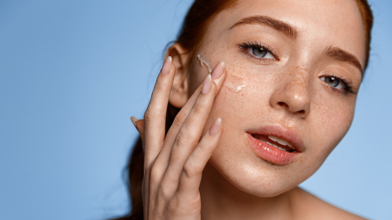 closeup of woman applying skincare