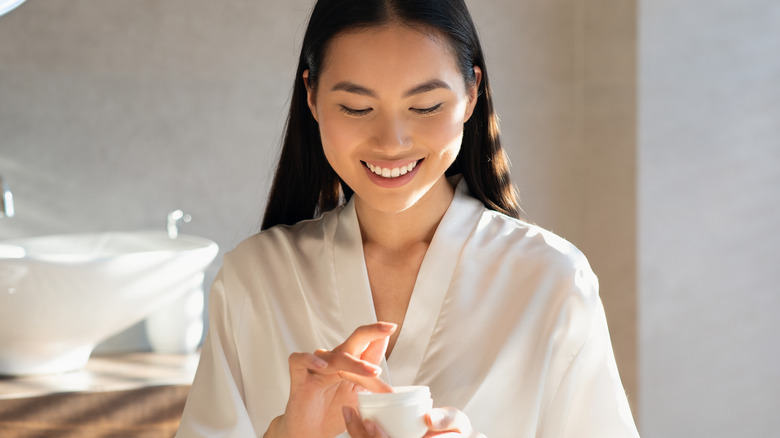 Asian woman using face cream 