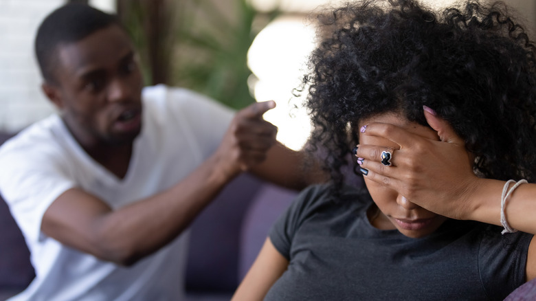 Man yells at woman on sofa