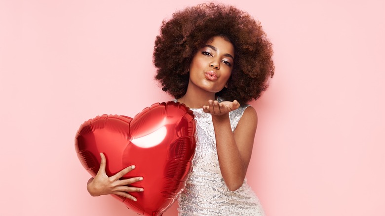 woman holding heart balloon