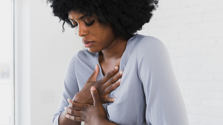 Woman clasping hands over her heart