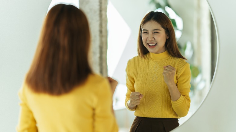 happy woman looking in mirror