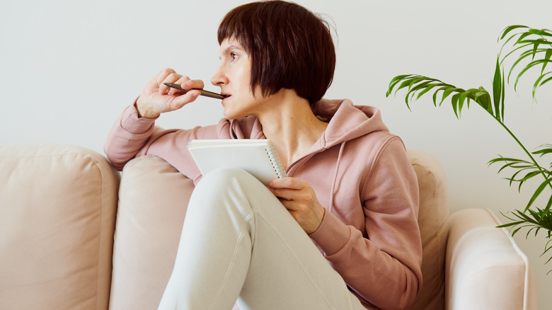 woman on sofa with journal