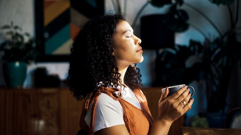 Woman meditating, holding mug