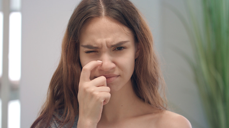 Woman scratching nose