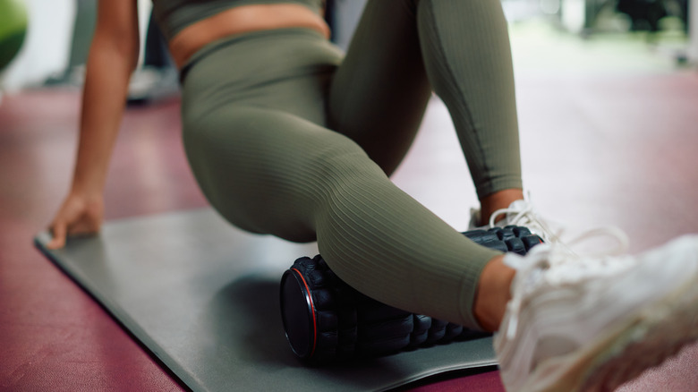 Woman foam rolling leg