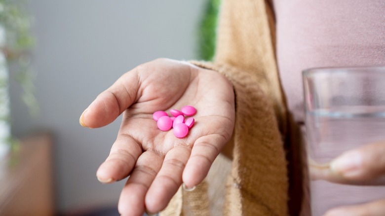 Hand filled with pink pills