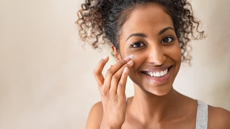 Woman applying facial moisturizer