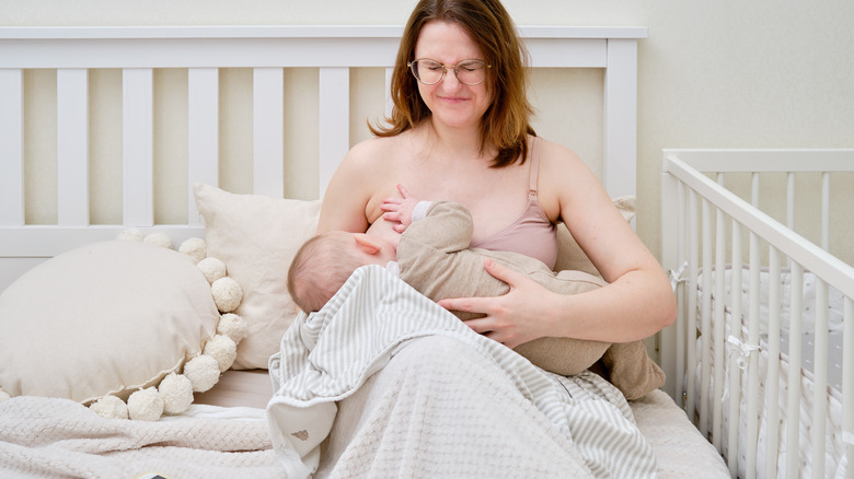 woman nursing baby in bed