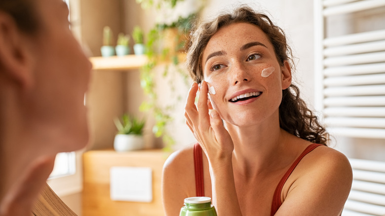 Woman applying moisturizer