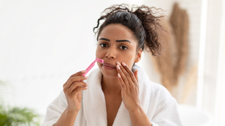 Woman shaving her face