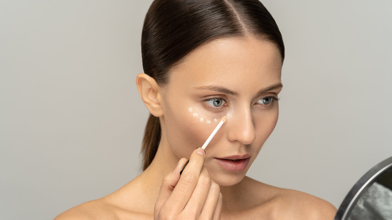 Woman applying concealer