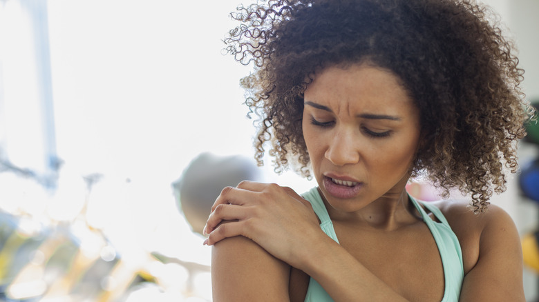 Woman rubbing her shoulder