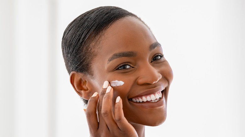 Woman applying skincare product