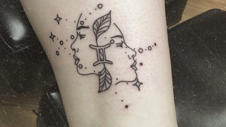 Twin faces with Gemini glyph tattoo