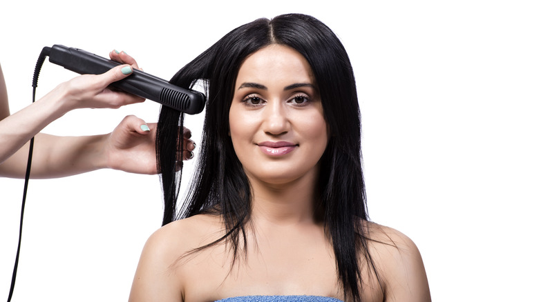 woman getting her hair straightened 