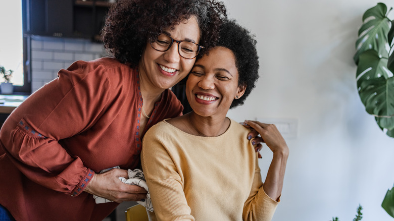 Women embrace over dinner