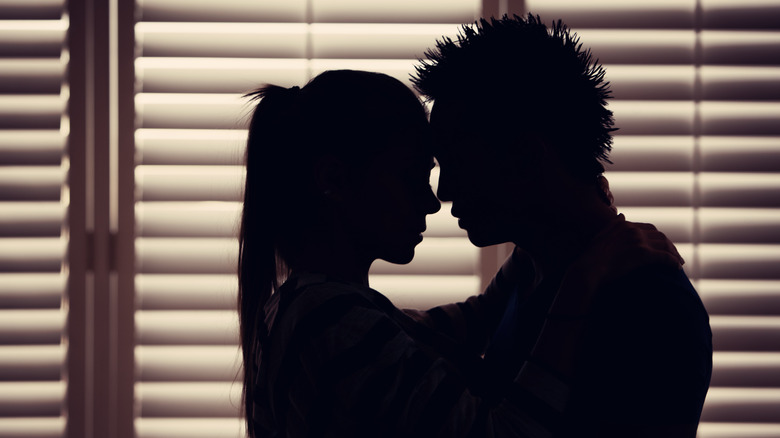 Couple embraces in darkness 