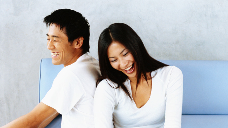 couple sitting on couch laughing