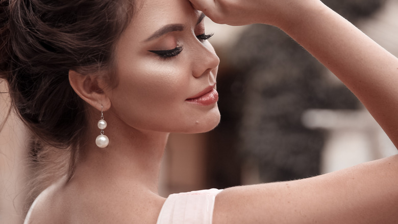 female wearing pearl earrings