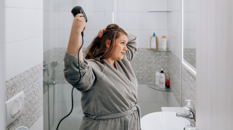 woman blowdrying her hair