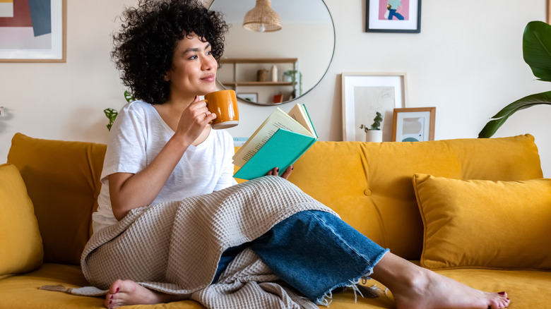 Woman reading book on sofa