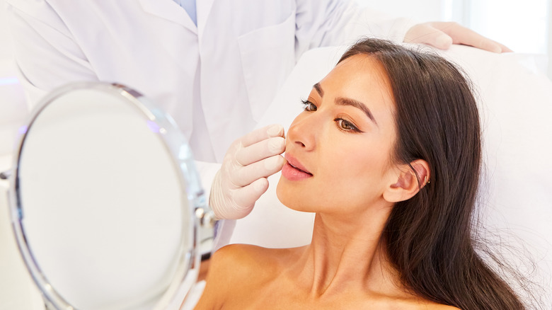 Patient looks at results of procedure in mirror